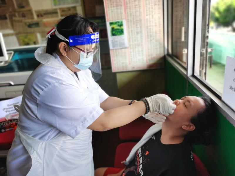 A nurse administers a nasal swab test in Kota Kinabalu, Sabah. (Photo credit: Alen Thien/Shutterstock)