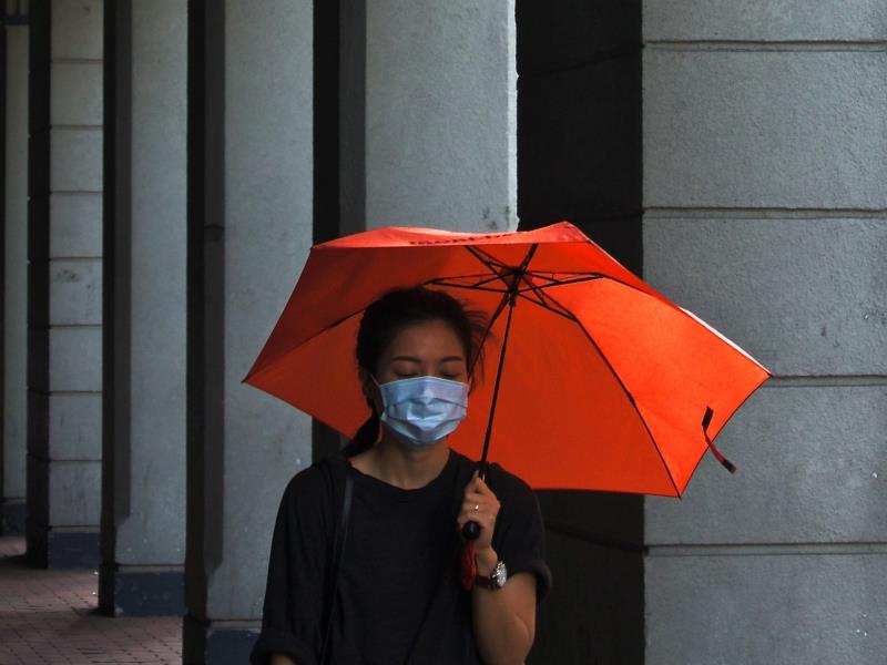 A woman in Hong Kong wears a face mask outdoors. (Photo credit: Tam Wai/Unsplash)