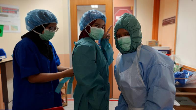 Healthcare workers donning PPE before attending to patients with COVID-19 in a Kuala Lumpur hospital. (Photo credit: Ham Hassan/Shutterstock)